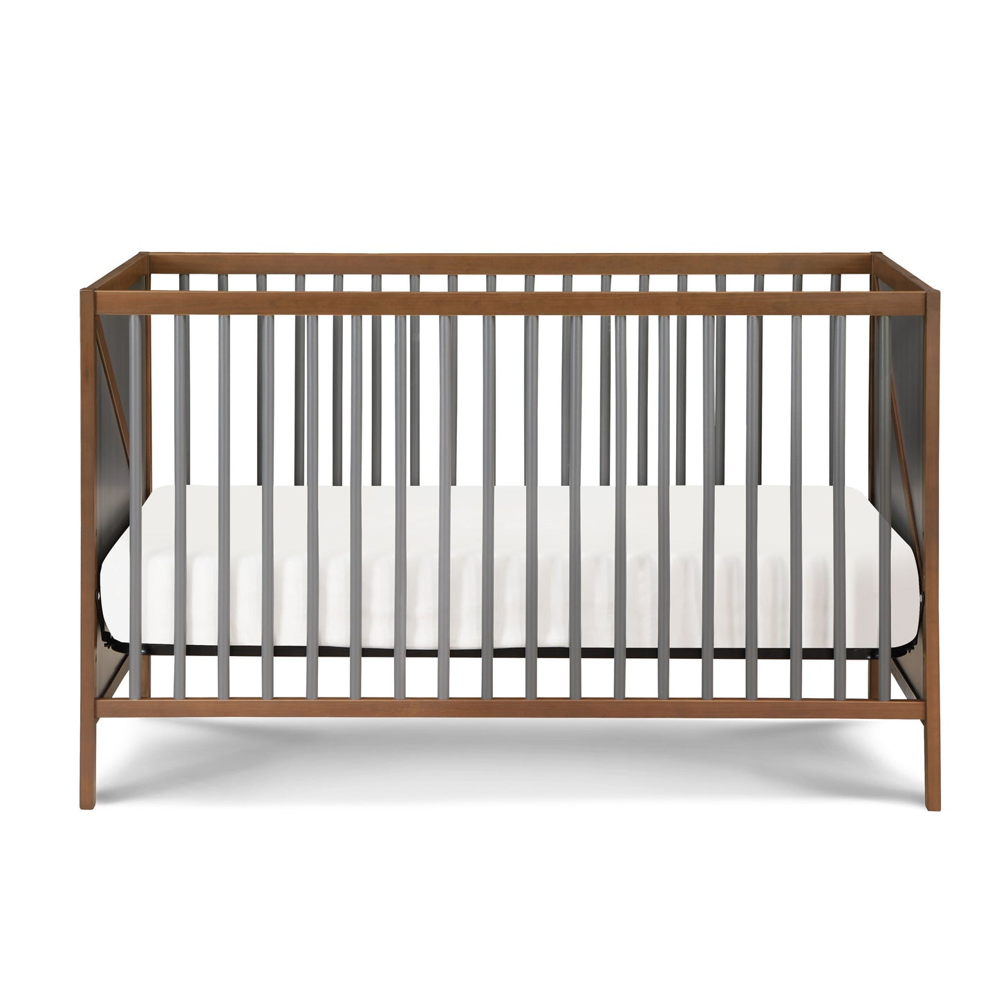 The Pixie Zen 3-in-1 Crib in walnut features a modern wooden frame, vertical dark gray slats, and comes with a white mattress inside.