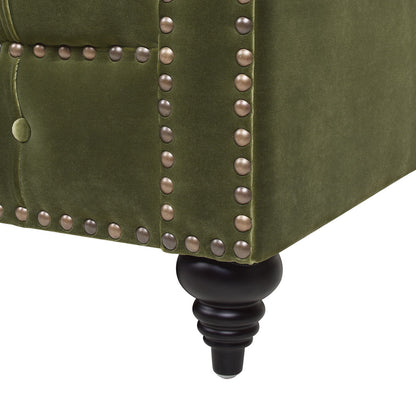 Close-up of Alto - Tufted Chesterfield Sofa in green upholstery, showcasing decorative brass nailhead trim and a black turned wooden leg.