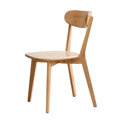 The Simple Dining Chair is a solid chair for the living room or dining area, featuring a curved backrest, angled legs, and a minimalist design in light-colored wood.