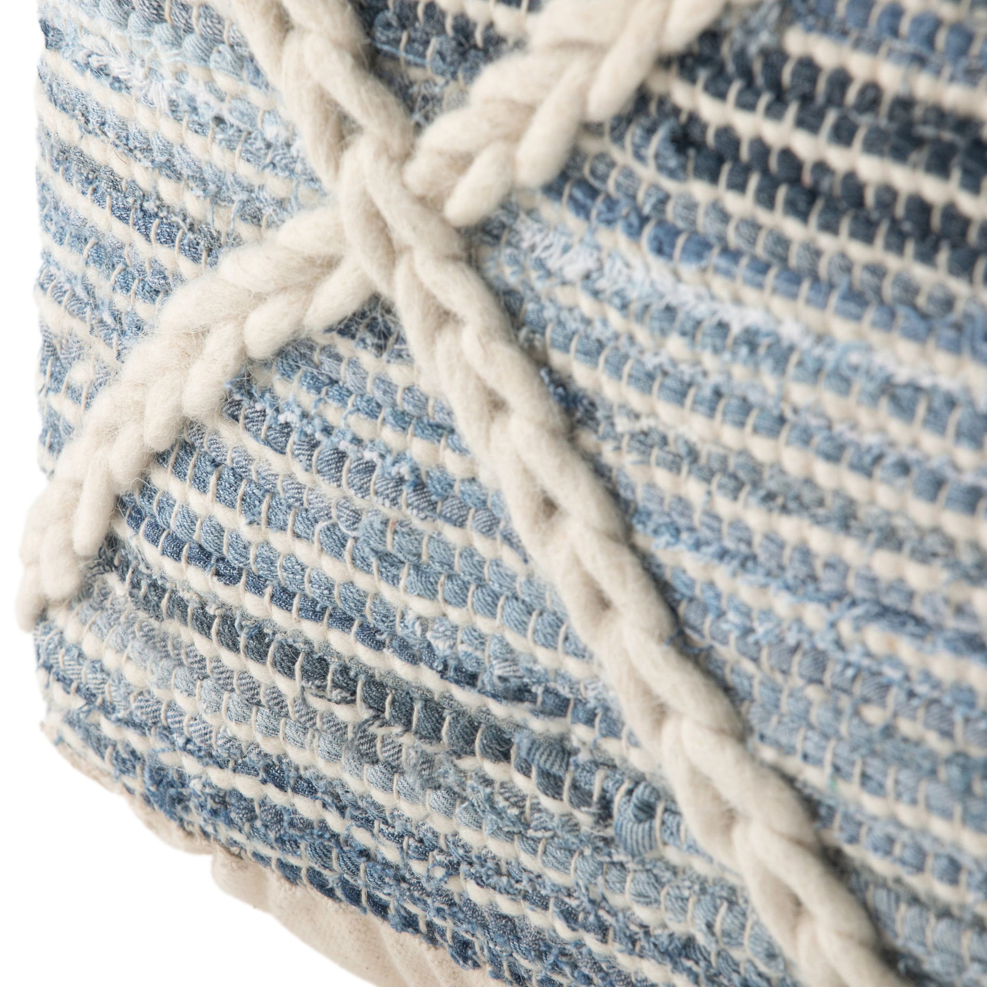 Close-up of the Cowan - Handcrafted Square Pouf, featuring blue and white woven fabric with thick cream braided yarn forming an "X" pattern. The soft, detailed texture adds a cozy touch to any room.