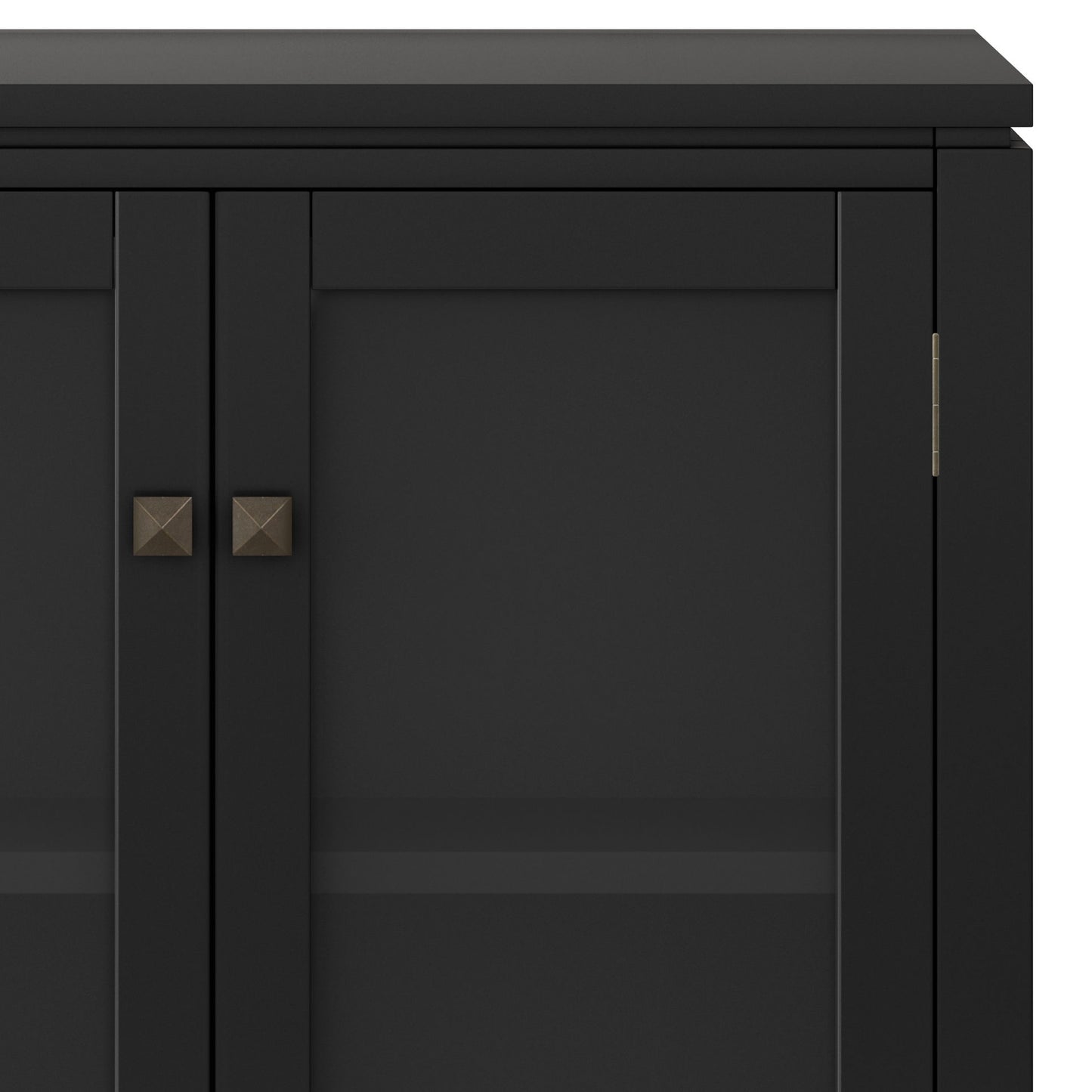 A close-up of the Cosmopolitan - Handcrafted Medium Storage Cabinet featuring black finish, glass doors, metal square knobs, and an interior shelf. The image highlights the upper section’s clean lines and minimalist style.