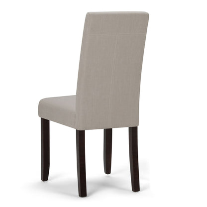 The Acadian Upholstered Parson Dining Chair (Set of 2) features a beige high backrest and dark wooden legs, shown from a rear side angle against a white background.
