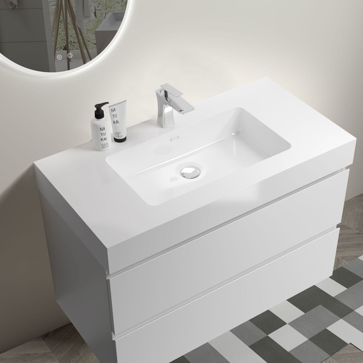 The Alice Bathroom Vanity is a modern, wall-mounted, floating vanity with a one-piece rectangular sink basin (no drain or faucet included), featuring clean lines and large storage. It’s shown on a geometric tiled floor with two soap bottles on the left.