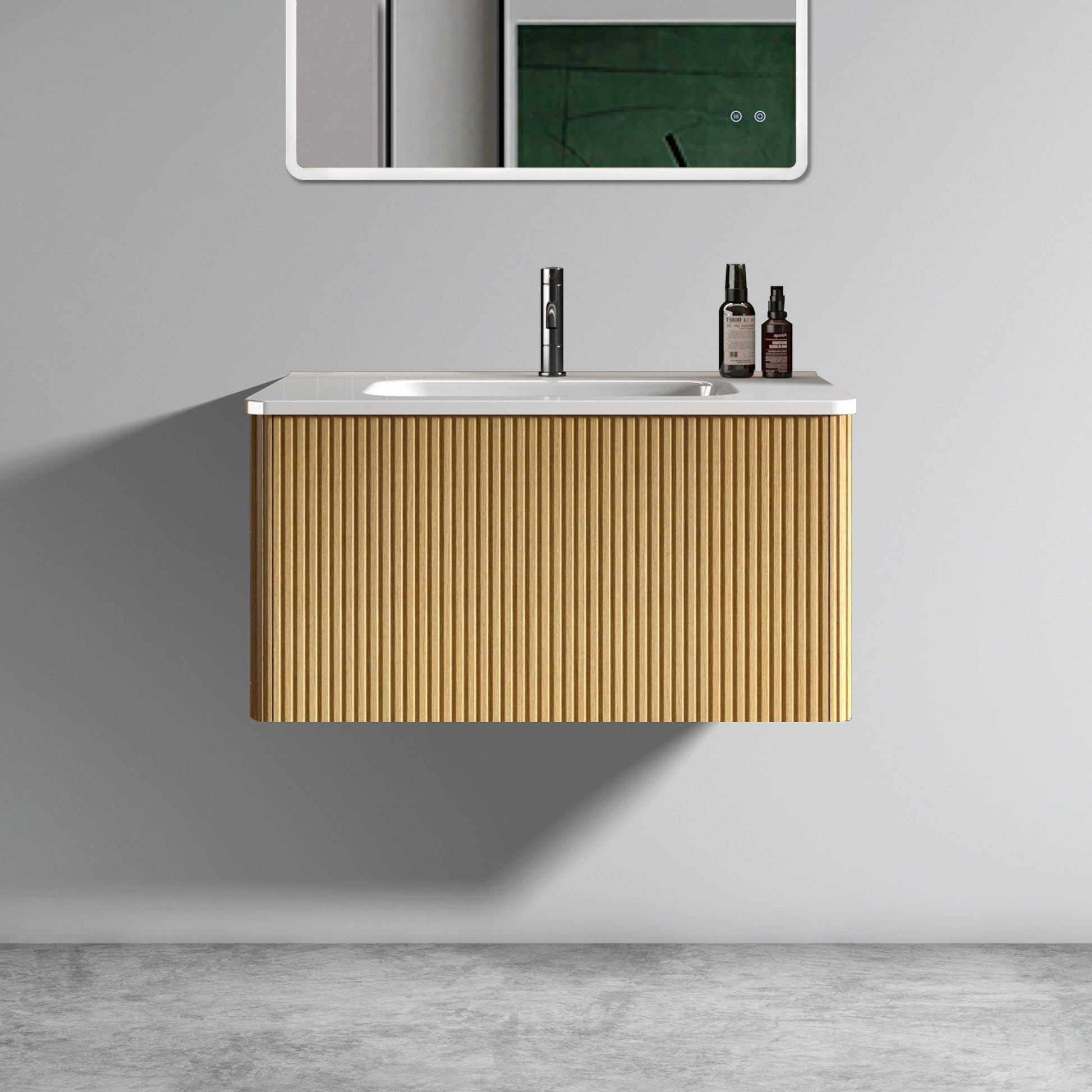 The Etna Striped Bathroom Vanity features a ribbed wooden front, white ceramic countertop with built-in sink, and is wall-mounted for a modern look. A faucet and toiletries rest on the counter; a mirror and green tile are reflected.