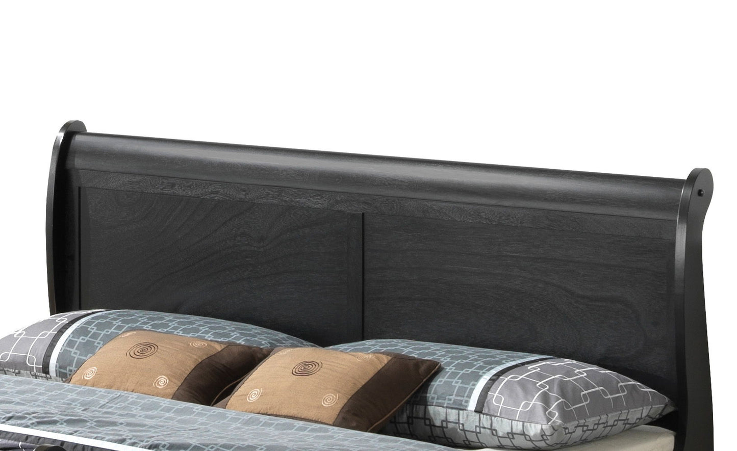 The Panel Sleigh Bed features a dark wood headboard with a simple, modern design, displayed behind a neatly made bed dressed in patterned blue and gray bedding and accented with brown pillows.