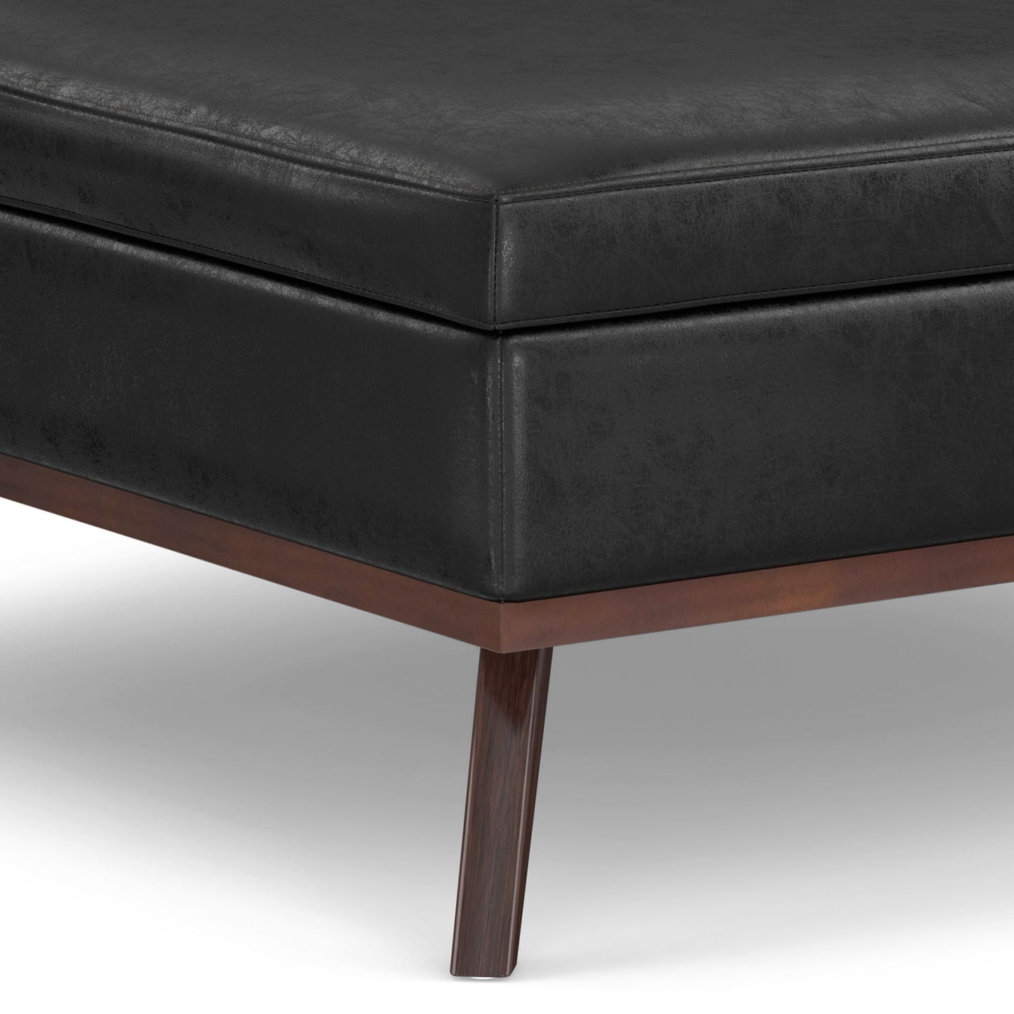 Close-up of the Owen - Multifunctional Square Coffee Table Storage Ottoman, featuring a black leather finish with a wooden frame and tapered wooden legs, set against a white background.