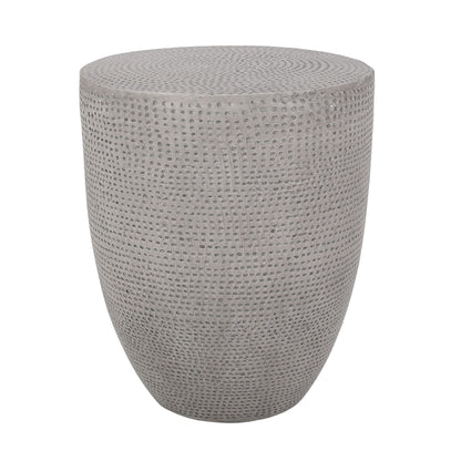 The Outdoor Lightweight Concrete Side Table in Natural features a round, gray design with a textured, dotted surface and smooth, curved silhouette, shown against a white background.