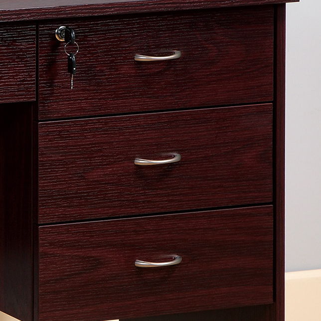 A mahogany student desk with three locking drawers on metal glides, featuring metal bar handles and a modesty panel; the top drawer shows a key inserted in its lock.