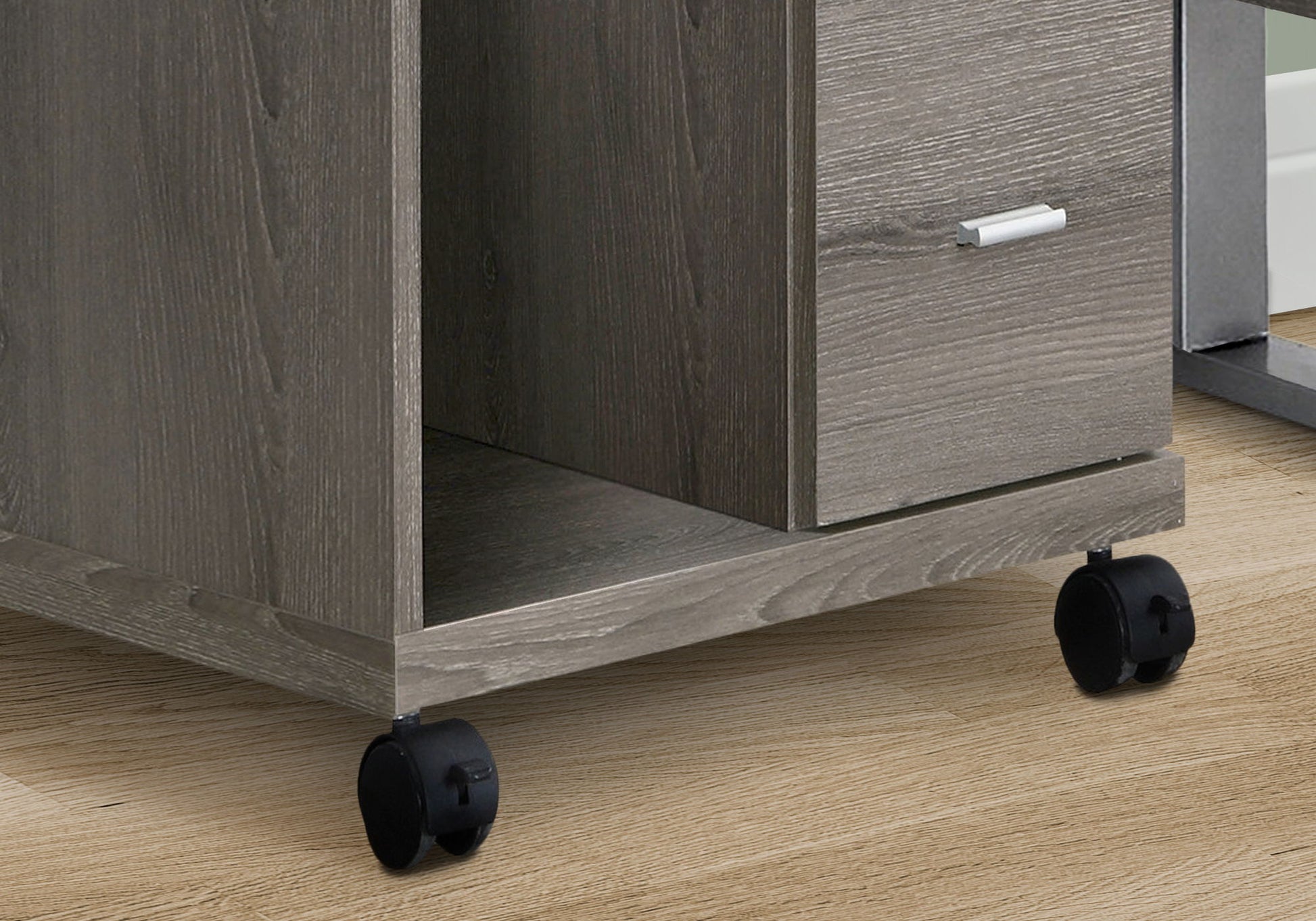 Close-up of the Office File Cabinet, a contemporary gray wooden printer cart with drawer and open shelf, standing on four black caster wheels on a light wood floor.