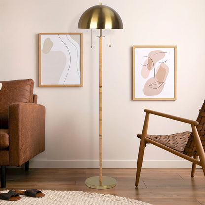 A modern living room corner with a brown leather sofa, woven chair, wood flooring, neutral decor, and the Allure 2 Light Floor Lamp in Gold with a Natural Tube and double pull chain beside two abstract prints on a cream wall.