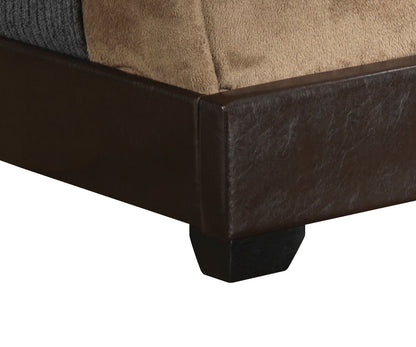 Close-up of the corner of the Elegant Platform Bed For Relaxed Spaces, featuring dark brown faux leather upholstery, a wooden leg, and a tan and gray blanket draped over the edge.