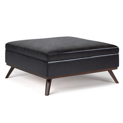 The Owen Multifunctional Square Coffee Table Storage Ottoman features black leather upholstery and angled wooden legs, shown against a white background.
