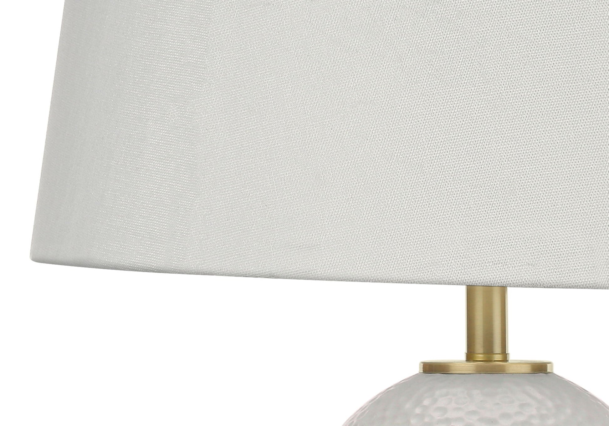Close-up of a Lighting Table Lamp in transitional style, featuring a textured white ceramic base and plain white fabric lampshade.