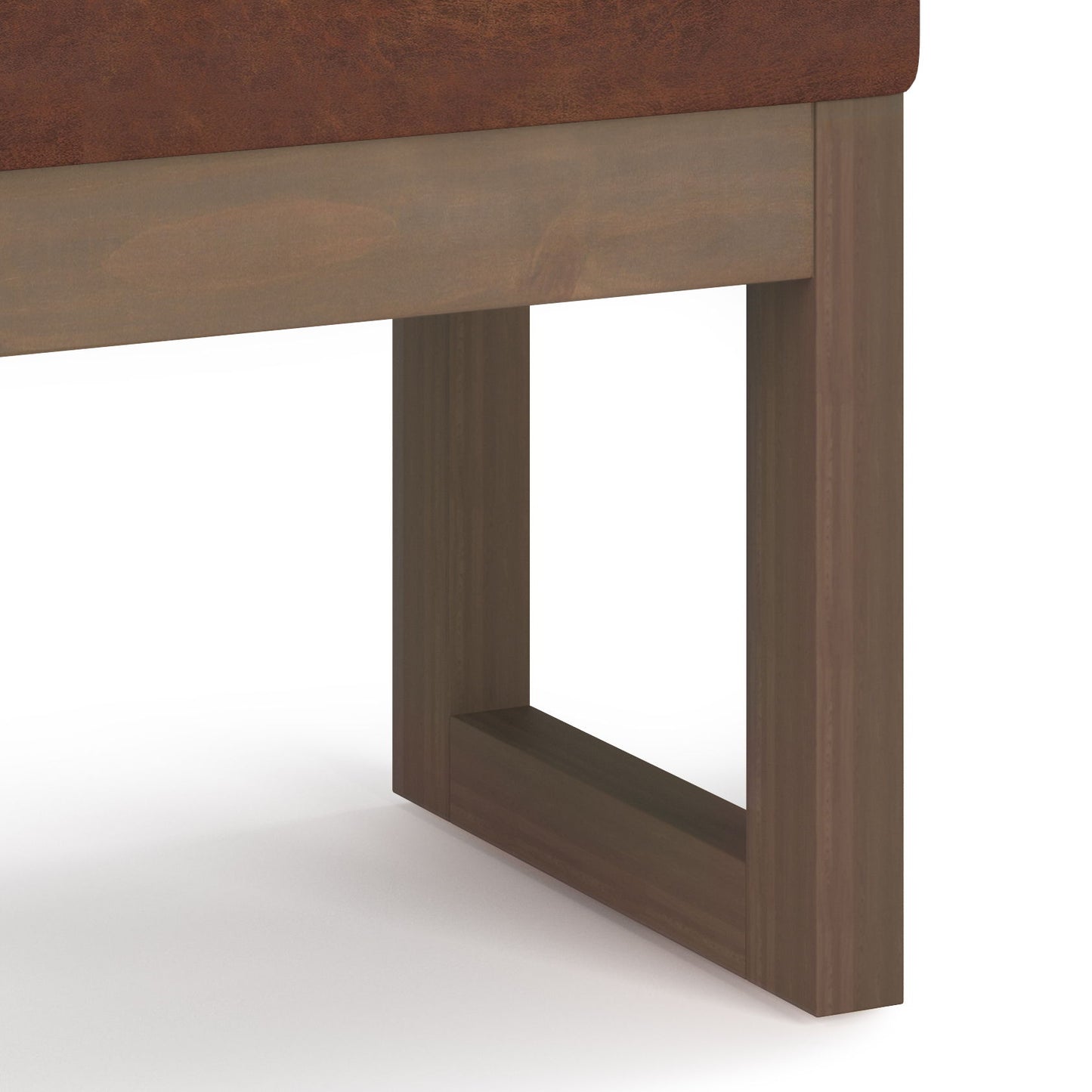 Close-up of the Milltown - Upholstered Ottoman Bench's wooden leg, featuring a rectangular open-frame design and smooth medium-brown finish, supporting brown upholstery, set against a white background.