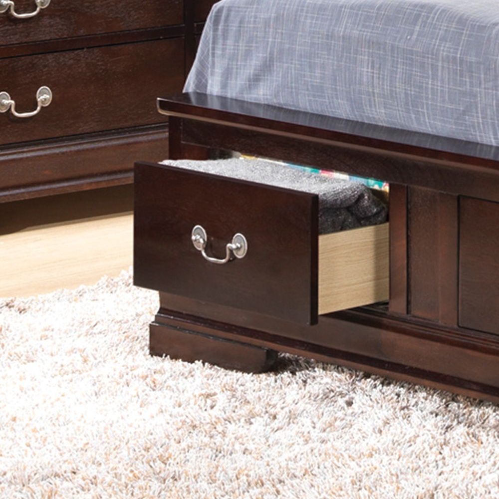 The Louis Phillipe Storage Bed features a dark wood frame with an open storage drawer at the foot, showing folded clothes inside. It is topped with a gray striped sheet and set on a light, shaggy carpet.