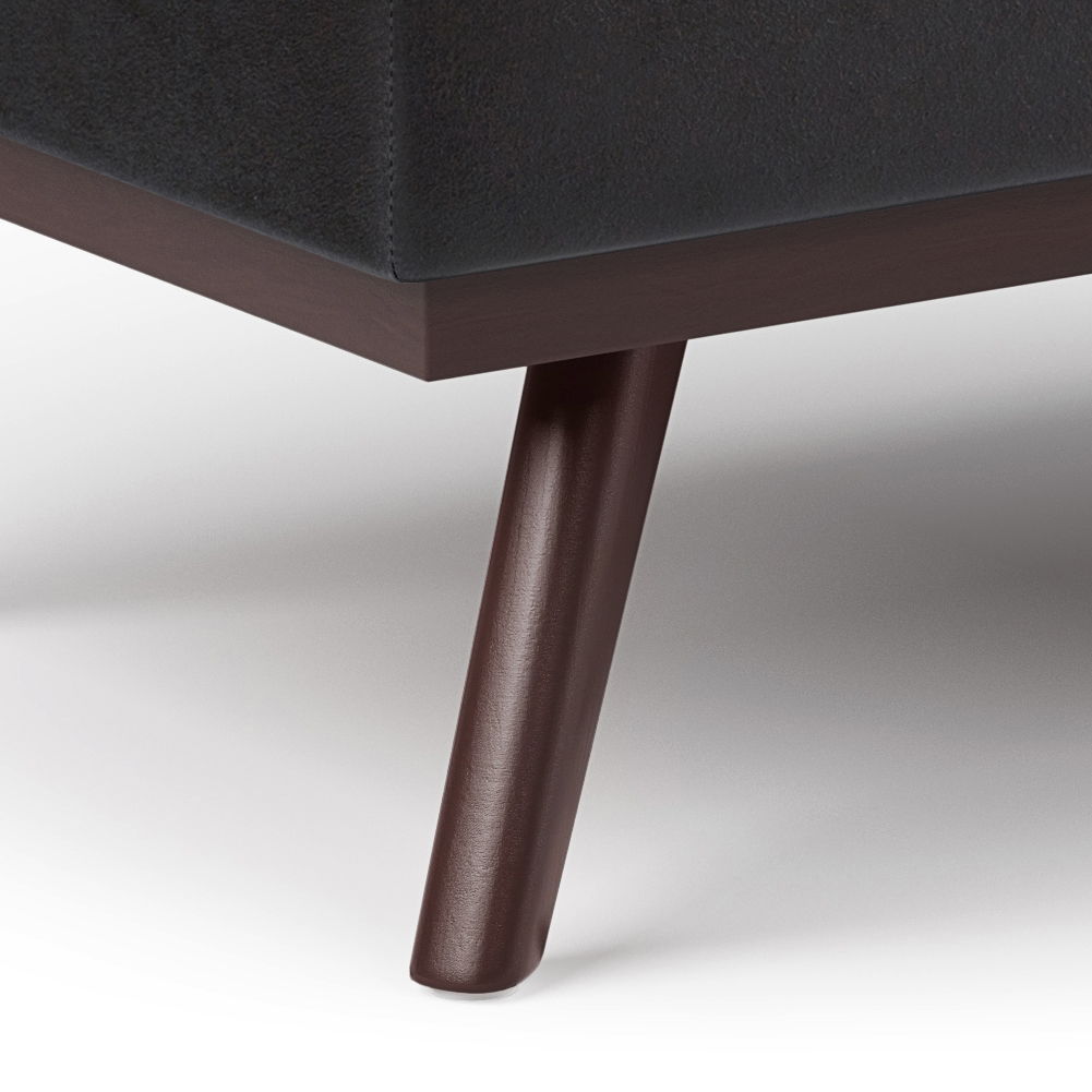 Close-up of a dark wooden leg supporting the Owen Lift Top Large Coffee Table Storage Ottoman, featuring dark upholstery and a clean, modern mid-century design on a white background.
