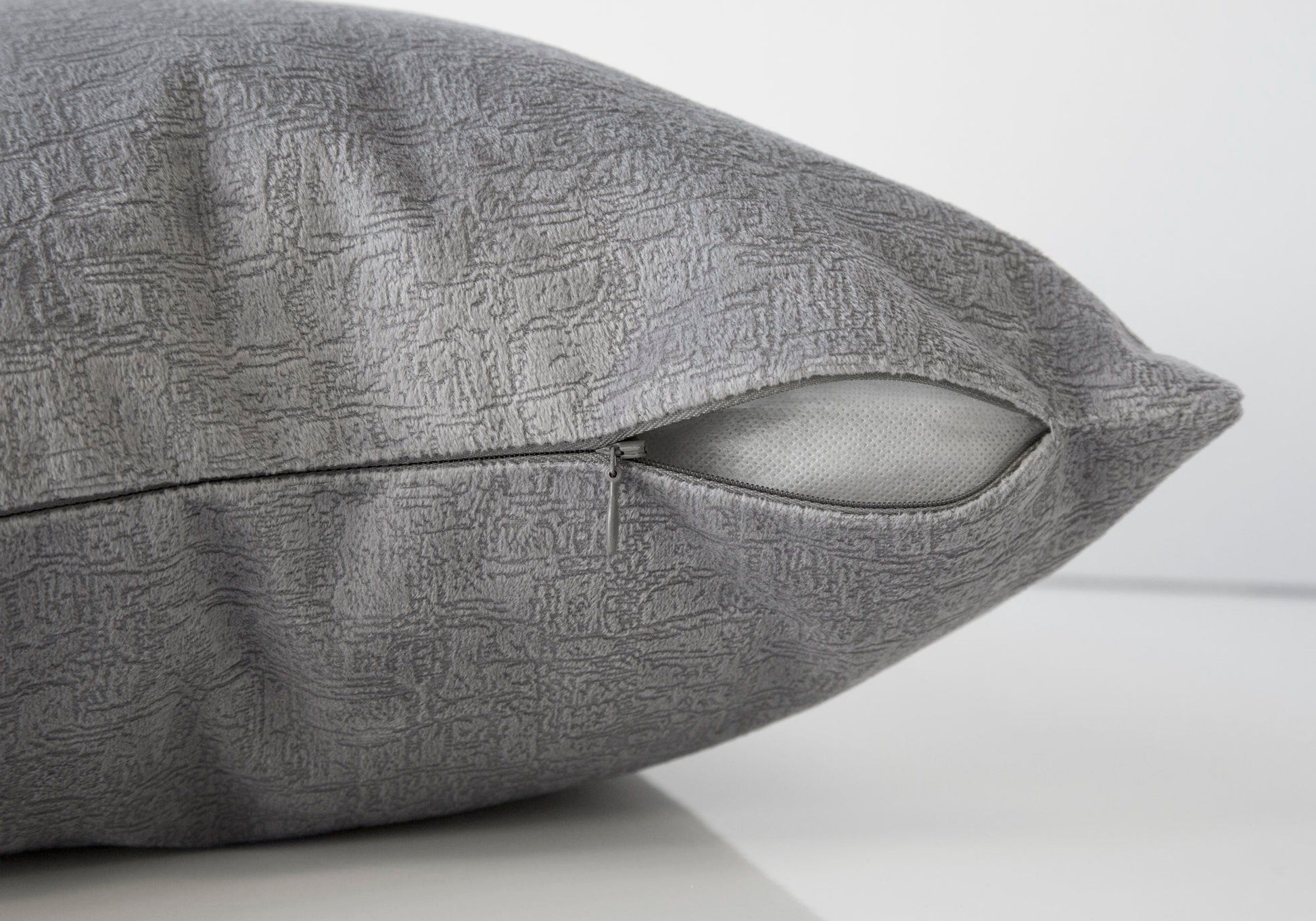 A close-up of the Pillow Square, a gray decorative throw pillow with a textured cover and hypoallergenic insert. The partially open zipper reveals the white inner pillow. Background is plain white. Insert included.