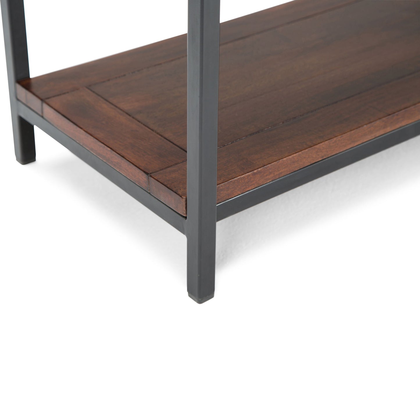 Close-up of a Skyler - Handcrafted Table shelf corner featuring dark metal legs and a richly finished brown wooden shelf. The modern, sturdy design highlights clean lines and quality materials.