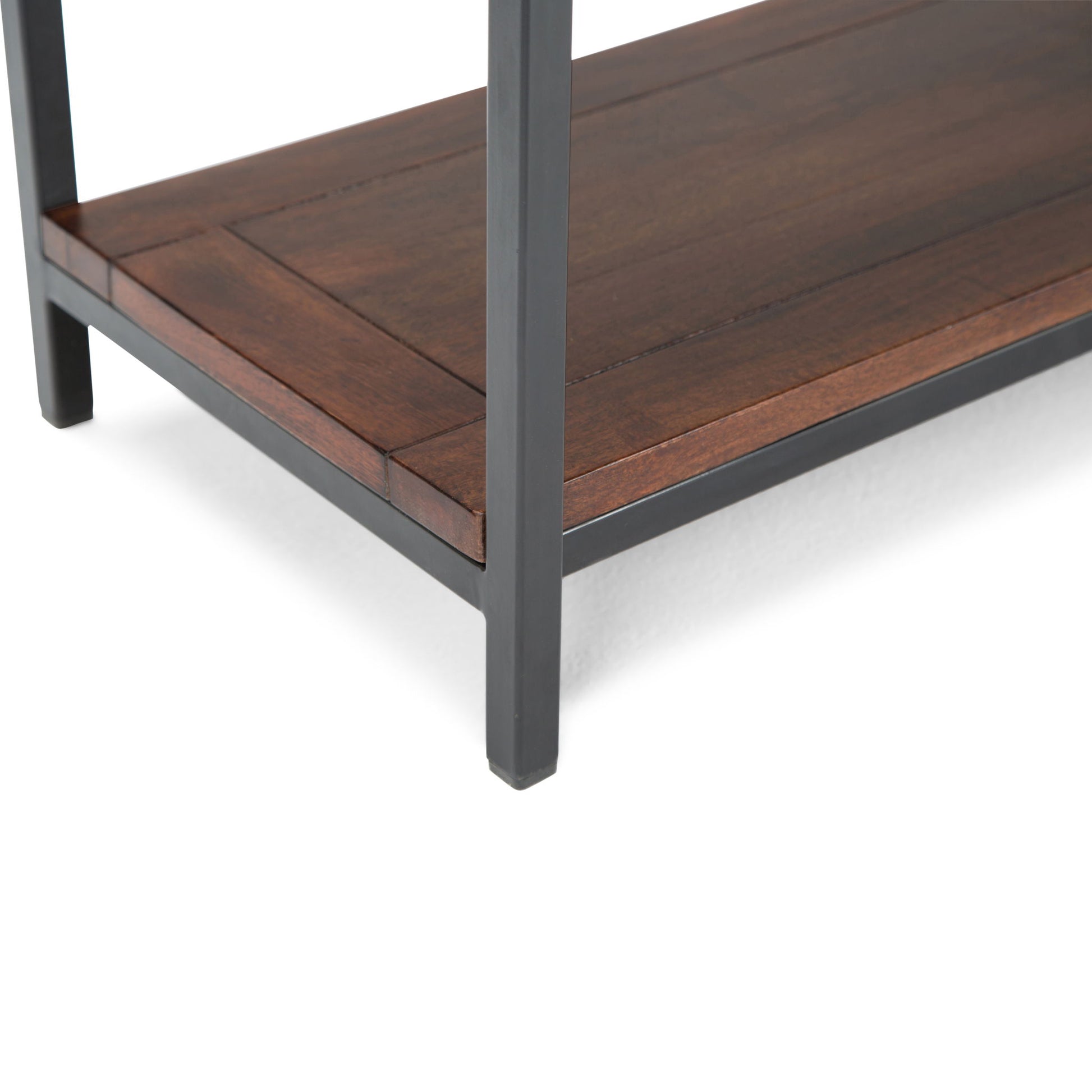 Close-up of a Skyler - Handcrafted Table shelf corner featuring dark metal legs and a richly finished brown wooden shelf. The modern, sturdy design highlights clean lines and quality materials.
