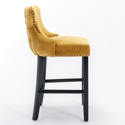 Side view of a yellow Contemporary Velvet Upholstered Wing-Back Barstool with button tufted back, chrome nailhead trim, and dark wooden legs, from the set of 2 Leisure Style Bar Chairs shown against a plain white background.