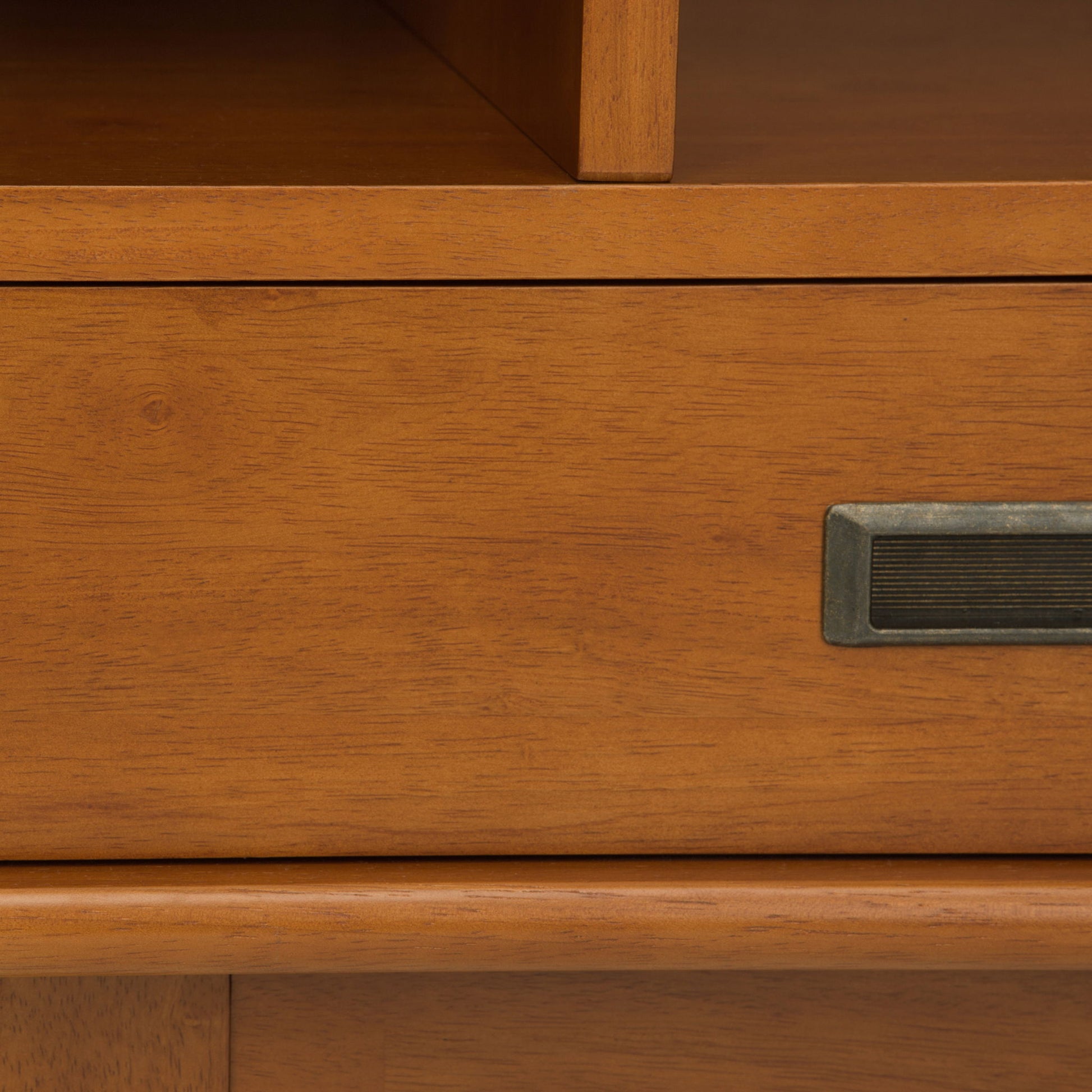 Close-up of the Draper - Mid Century Wide Bookcase And Storage Unit, highlighting its smooth wood texture, warm brown finish, and rectangular brass handle.