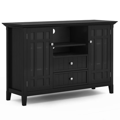 The Bedford Handcrafted Tall TV Media Stand is a black wooden sideboard with two paneled doors, two central drawers, two open shelves, silver square knobs, and a contemporary design.