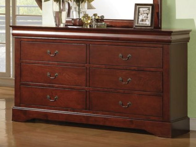 The Louis Philippe III Dresser features six drawers with metal handles and durable construction, displayed with decorative items, a framed photo, and a mirror behind it against a light green wall.