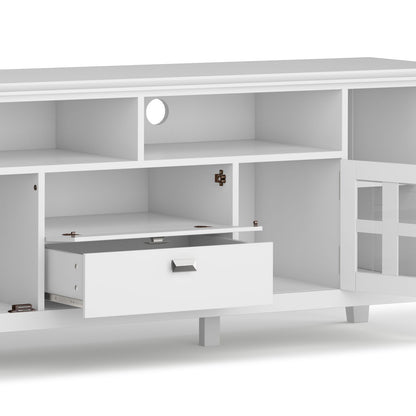 The Artisan - TV Media Stand is white with open shelves, a drawer, and cabinet doors; one cabinet door and the drawer are partly open, revealing storage inside. A circular cable management hole is located at the back.
