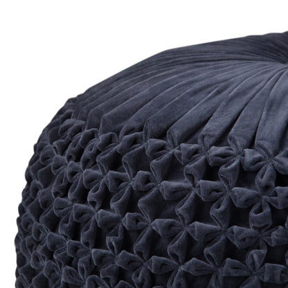 Close-up of the Renee - Handcrafted Round Pouf, featuring dark blue, pleated and tufted velvet with a geometric honeycomb pattern.
