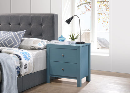 A modern bedroom with a gray tufted bed, patterned bedding, and a Charming Nightstand With Drawers holding a lamp, potted plant, book, and blue jar, set by a large window showing autumn leaves.