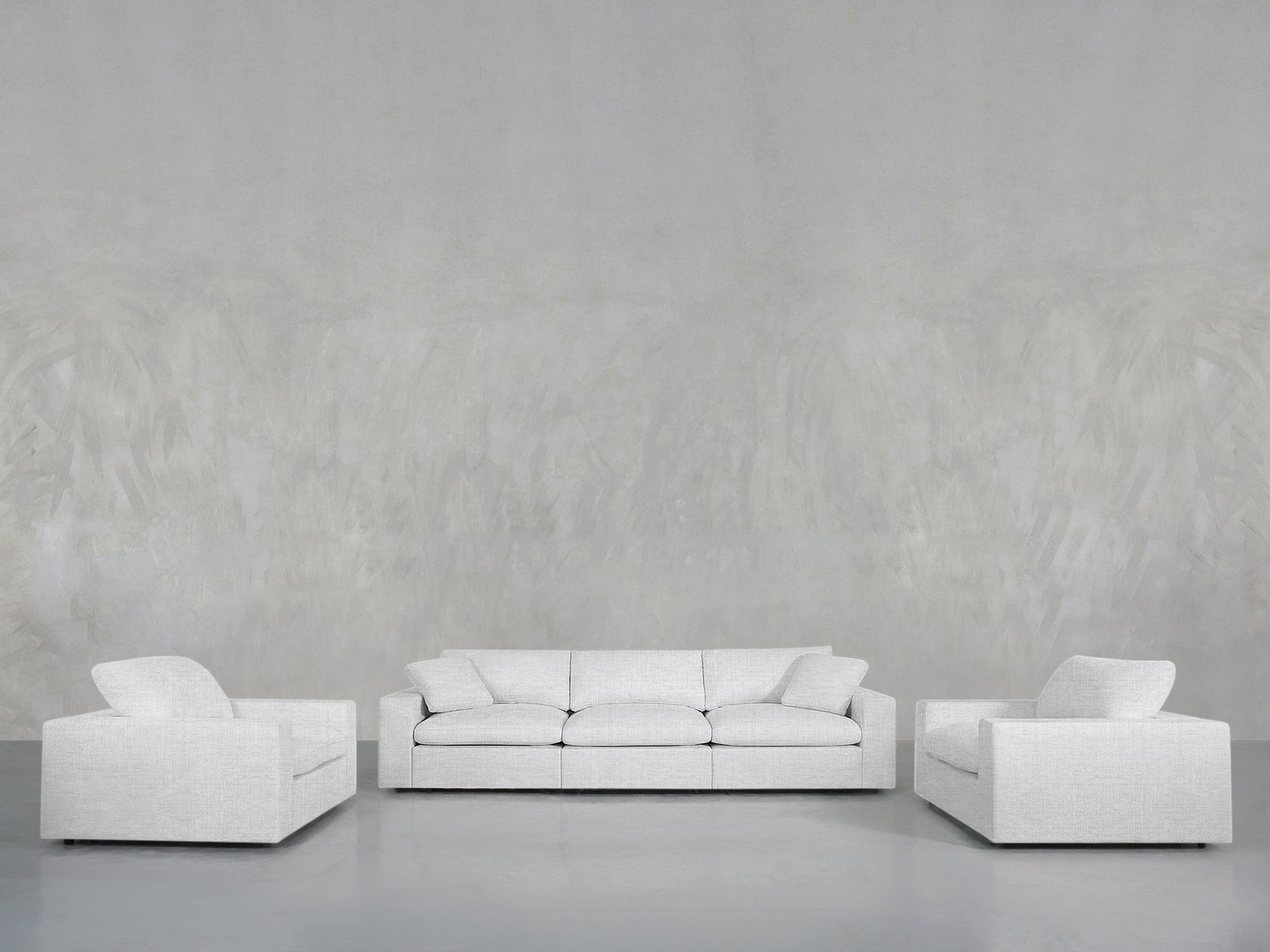 A minimalist living room setup with the 3-1-1 Sofa & Armchair Set in light gray, featuring a three-seater sofa between two matching armchairs, all against plain light gray textured walls and floor.