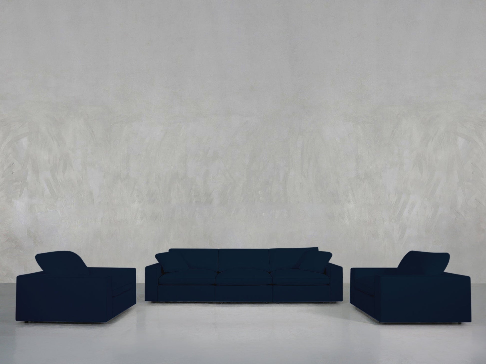 A minimalist room features the 3-1-1 Sofa & Armchair Set in navy blue, including a three-seater sofa and two matching armchairs, against a light gray textured wall and polished white floor.