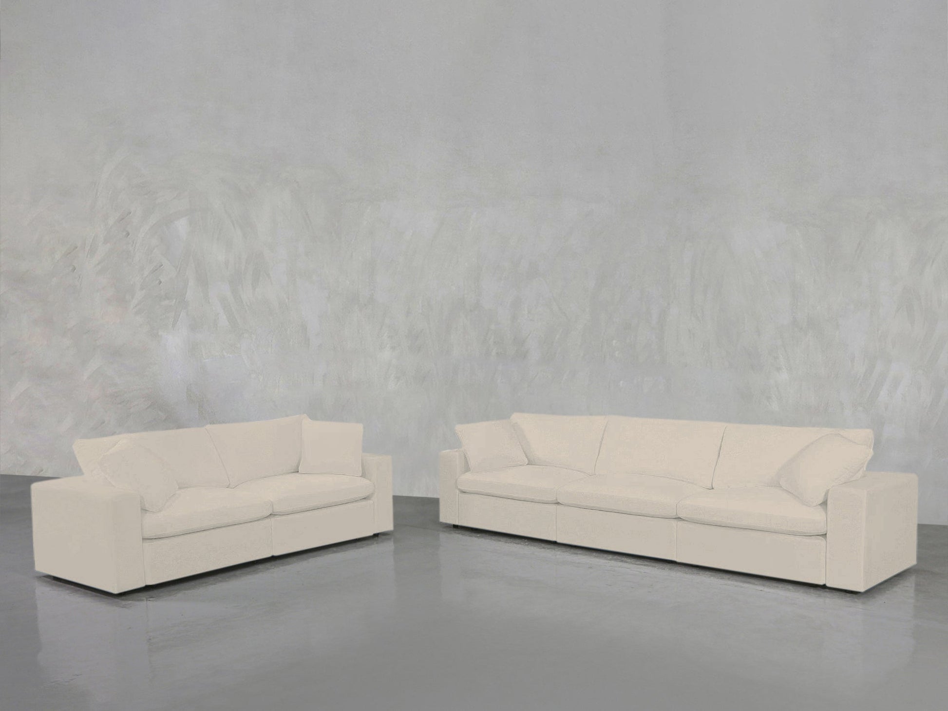 A 3-2 Sofa Set with modern design, white upholstery, and plush cushions sits on a polished grey floor against a textured light grey wall.