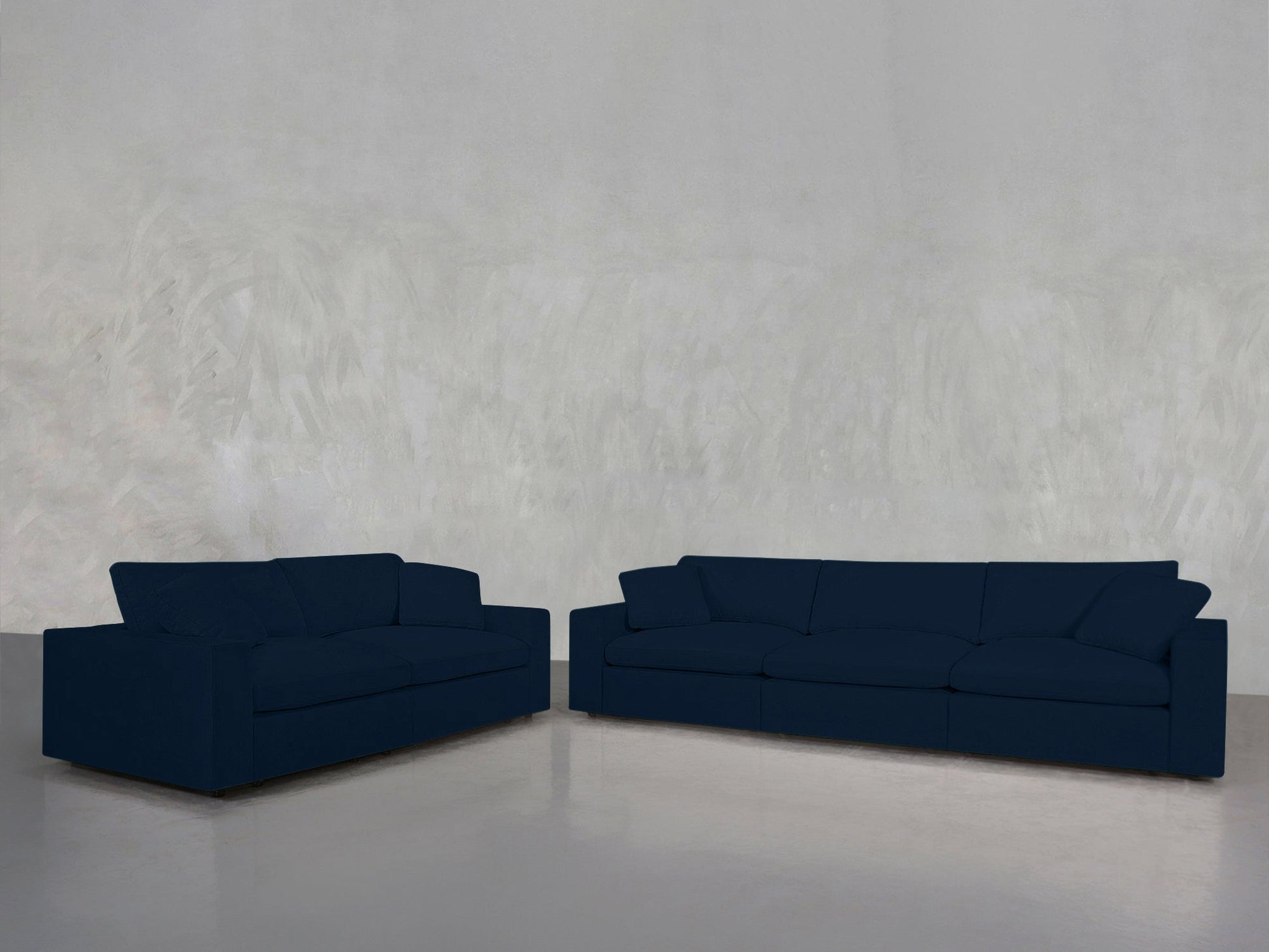 A 3-2 Sofa Set in dark blue sits against a light gray textured wall on a shiny gray floor in an empty room.