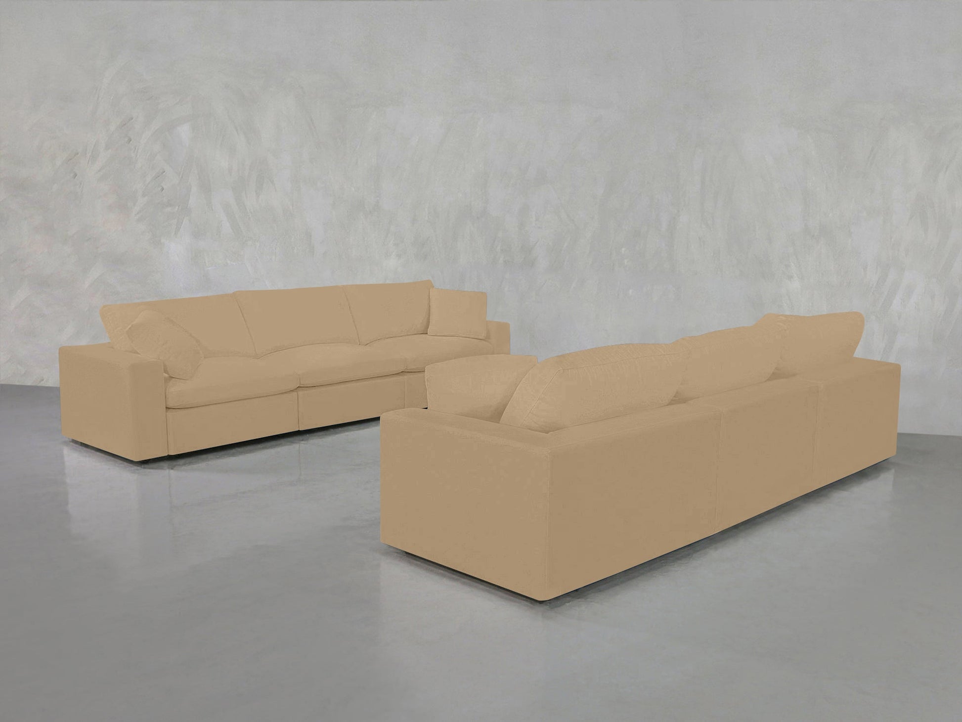 The 3-3 Sofa Set, featuring two tan modern sofas, is arranged on a shiny gray floor against a light gray textured wall in a minimalistic room.