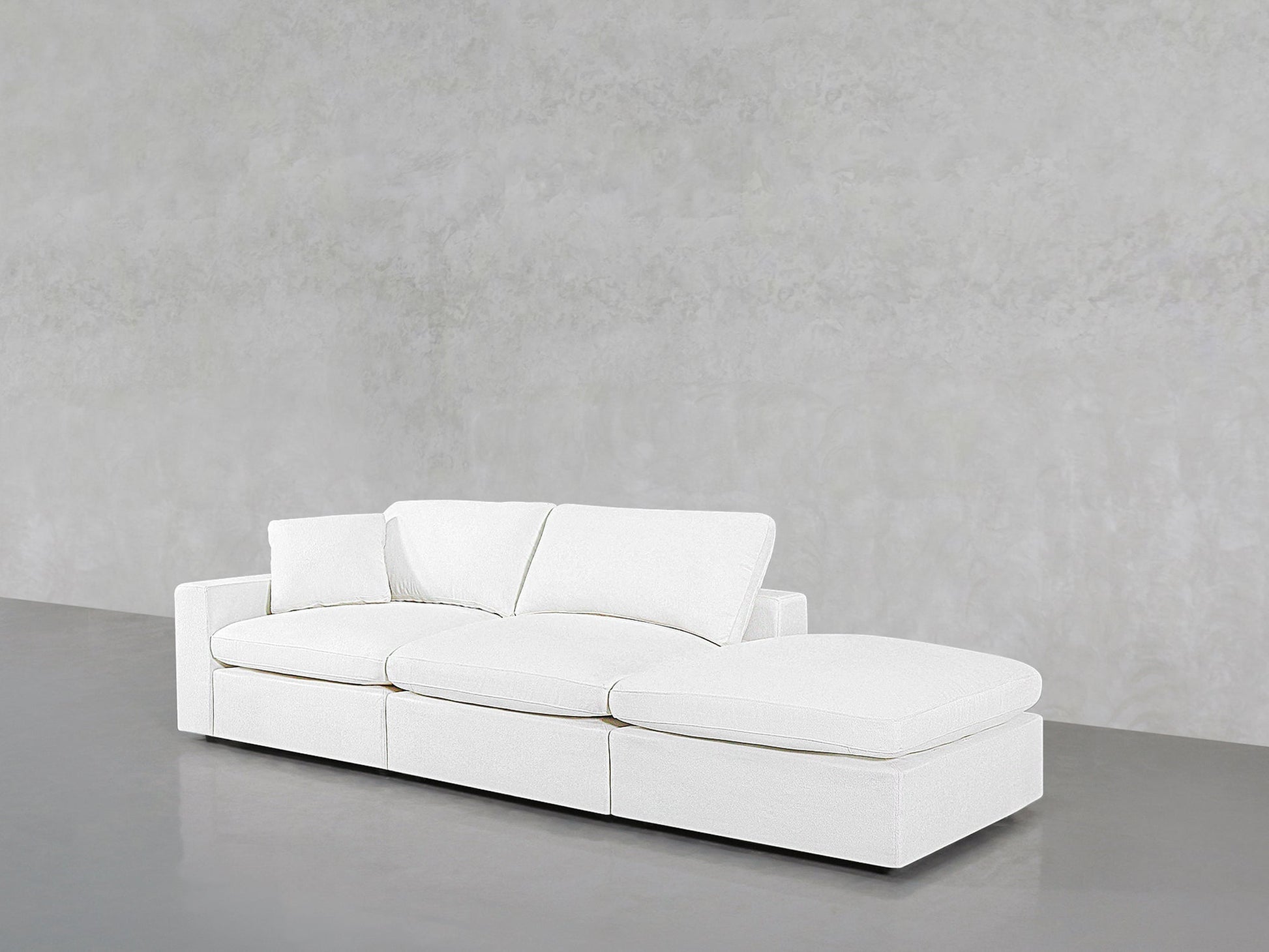 The 3-Seat Modular Lounger Sofa in modern white features a right-side chaise, set against a plain light gray textured wall and floor.