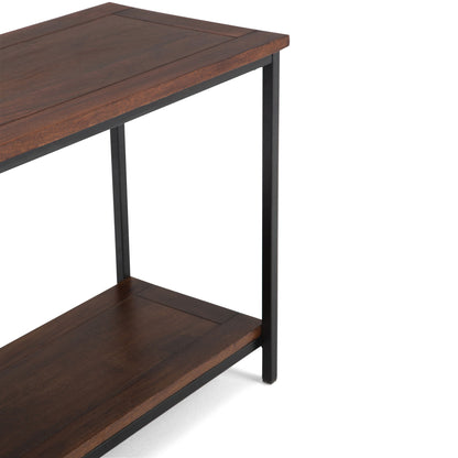 A close-up view of the Skyler - Handcrafted Table, featuring a dark wood top and shelf supported by a black metal frame. Its design is simple and minimalist.