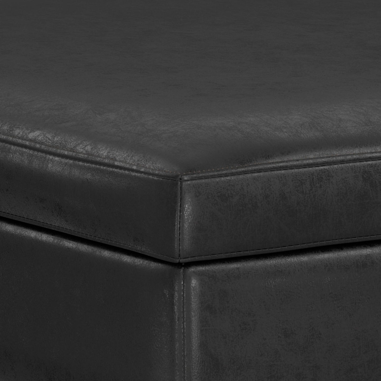 Close-up of the corner of the Owen Multifunctional Square Coffee Table Storage Ottoman, highlighting its black leather-like upholstery, textured surface, and detailed stitching along the edges.