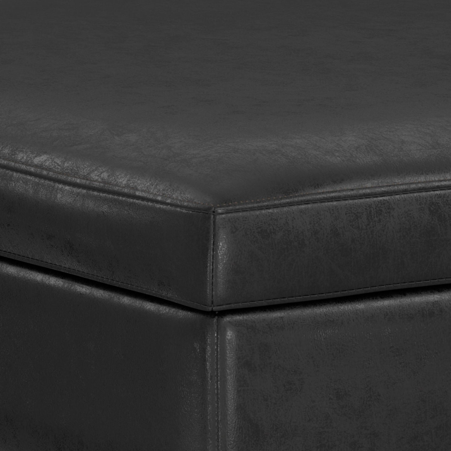 Close-up of the corner of the Owen Multifunctional Square Coffee Table Storage Ottoman, highlighting its black leather-like upholstery, textured surface, and detailed stitching along the edges.
