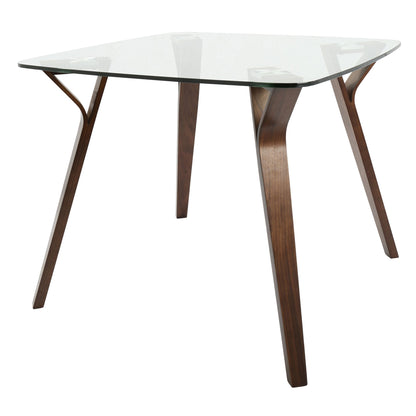 The Folia - Mid Century Modern Dinette Table features a clear rectangular glass top and four angled wooden legs with a dark finish in a sleek, minimalist design.