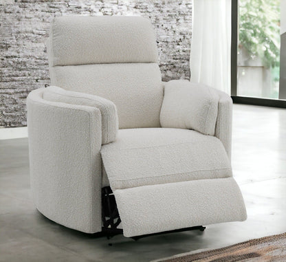 The Sagen Chenille Glider Recliner with Swivel features plush white textured upholstery and an extended footrest, shown in a bright room with large windows and a partially visible curtain.