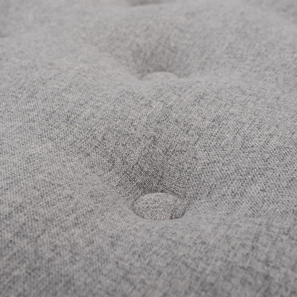 Close-up of the Yolanda Round Upholstered Accent Ottoman in light gray fabric, showcasing its soft texture and a centered, indented button tuft detail.