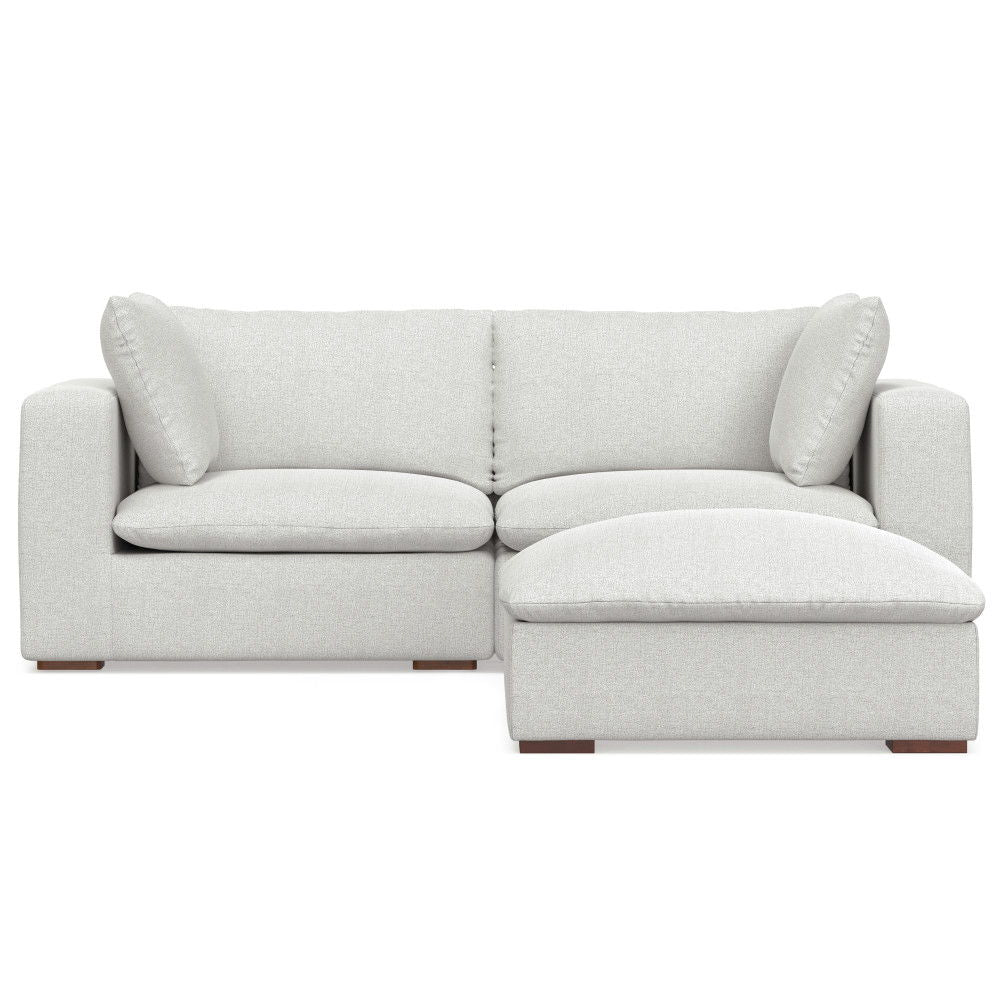 The Jasmine Handcrafted Sofa and Ottoman features a modern light gray design with two seat cushions, two large back cushions, two side pillows, and an attached right-side chaise lounge.