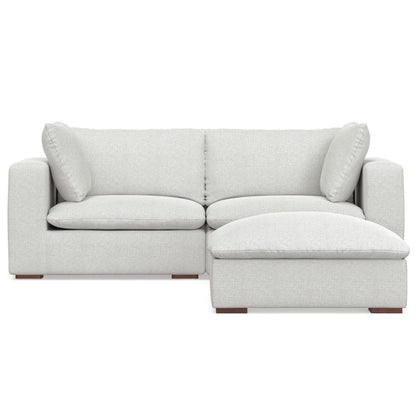 The Jasmine Handcrafted Sofa and Ottoman features a modern light gray design with two seat cushions, two large back cushions, two side pillows, and an attached right-side chaise lounge.