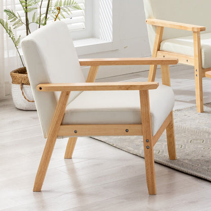 The Bahamas - Linen Fabric Chair features a light wood frame with white cushioned seat and backrest, placed on a light wood floor near a sunlit window. A potted plant and another matching chair are visible in the background.
