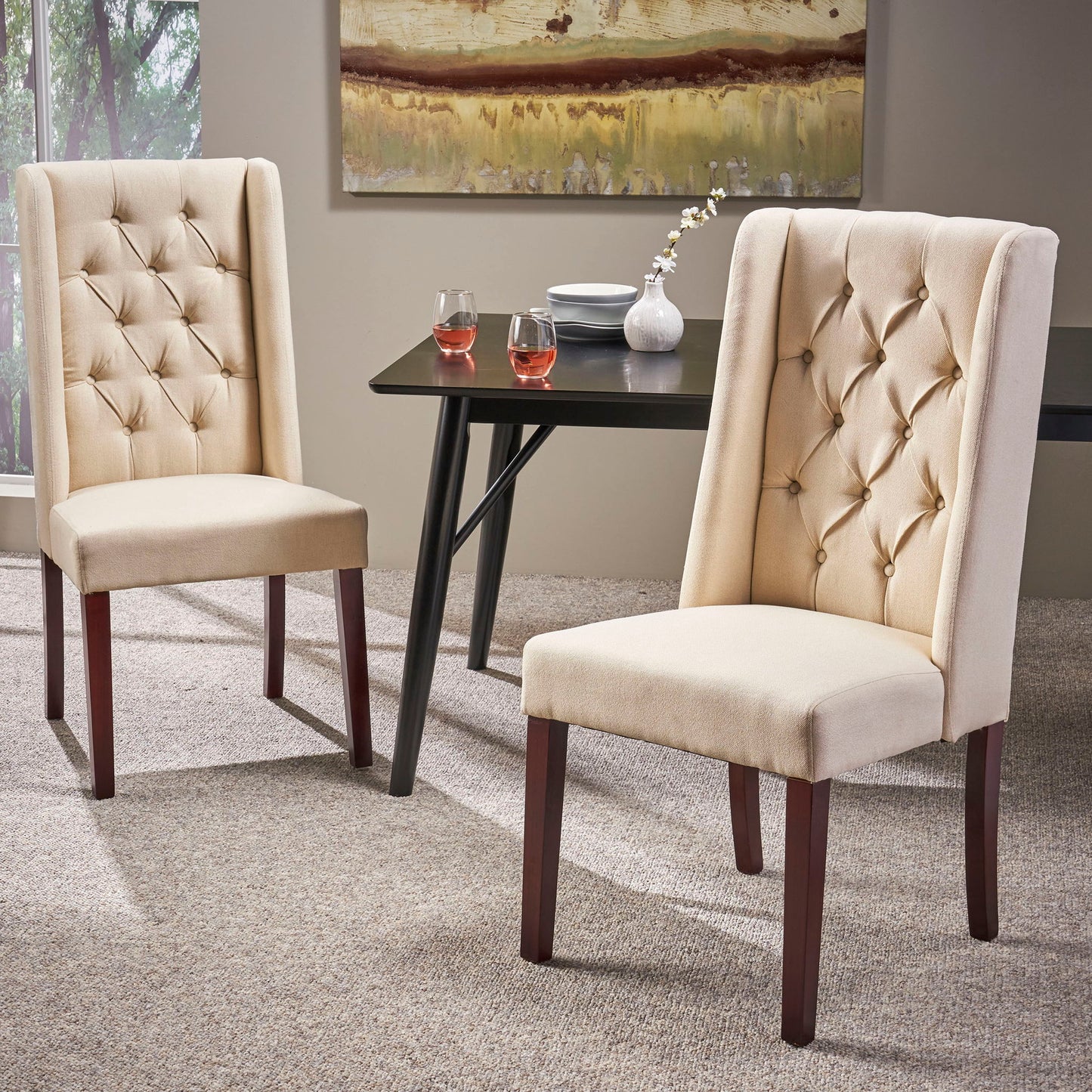 Two Sophisticated Tufted Dining Chairs With High Back Design in beige sit on a carpet near a dark rectangular dining table, set with two glasses of rosé, a white flower vase, and plates, creating a modern dining room ambiance.
