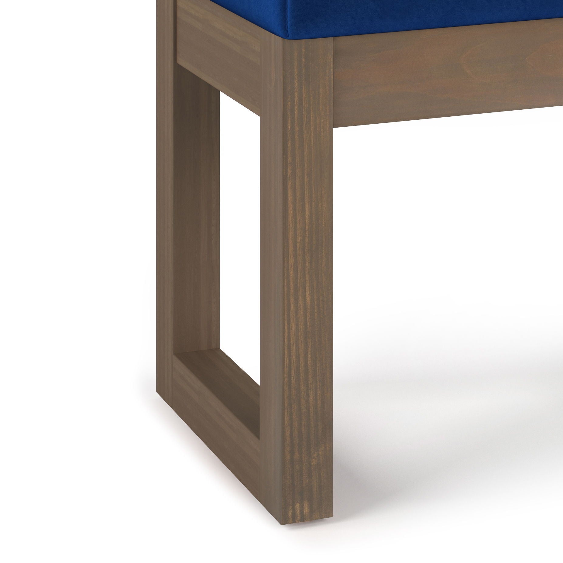 Close-up of the Milltown - Upholstered Ottoman Bench, featuring a wooden leg with a rectangular open-frame design and a blue cushioned seat, set against a white background.