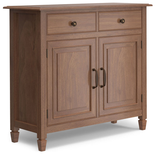 The Connaught - Entryway Storage Cabinet in Medium Saddle Brown features two small top drawers, two paneled doors with metal handles and knobs, a smooth finish, and stands on four short legs.