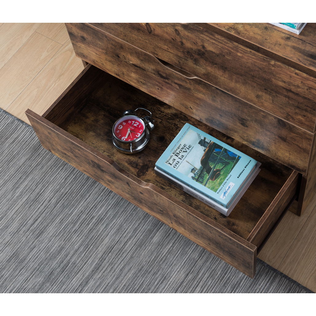 An open drawer of the 5 Drawer Bedroom Chest Dresser, Distressed Wood Cabinet, holds a red alarm clock and a tractor-cover book beside a gray textured rug on a light wood floor.