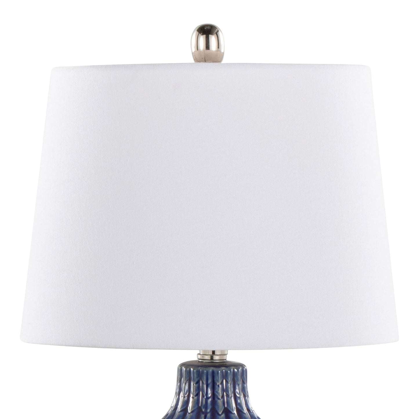 A close-up of the Rockwell - Contemporary Table Lamp (Set of 2), featuring a white cylindrical lampshade with a silver finial and a textured blue base partially visible.
